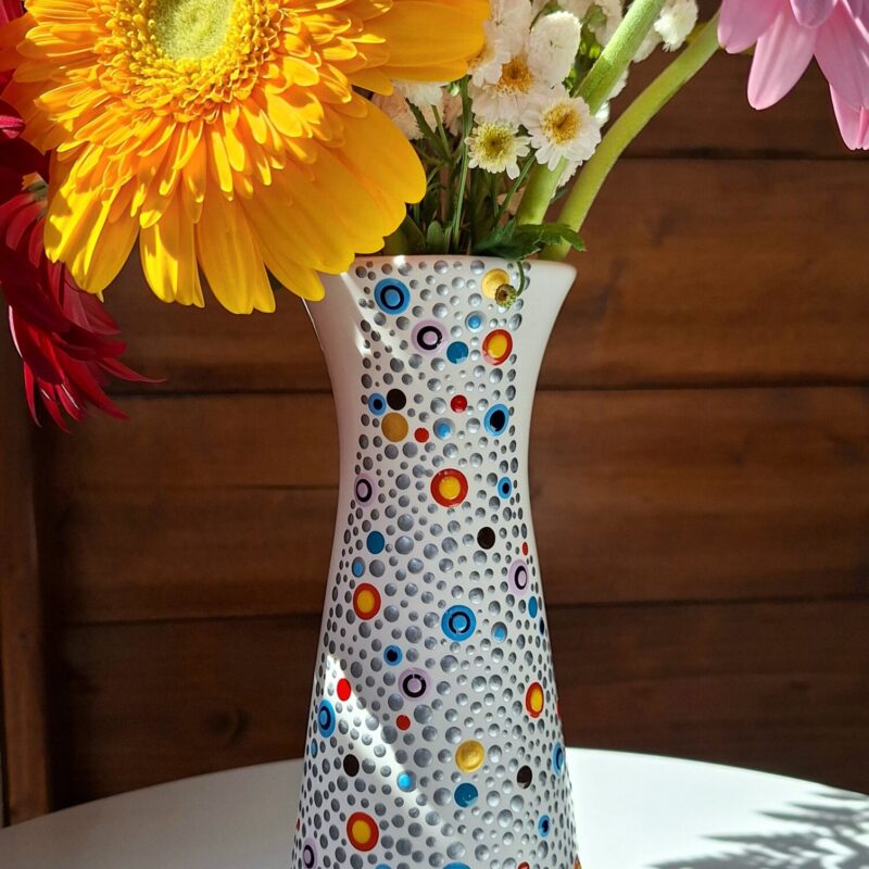 Prekrasna ručno ukrašena bijela vaza sa točkama u raznim bojama, pogled bočni